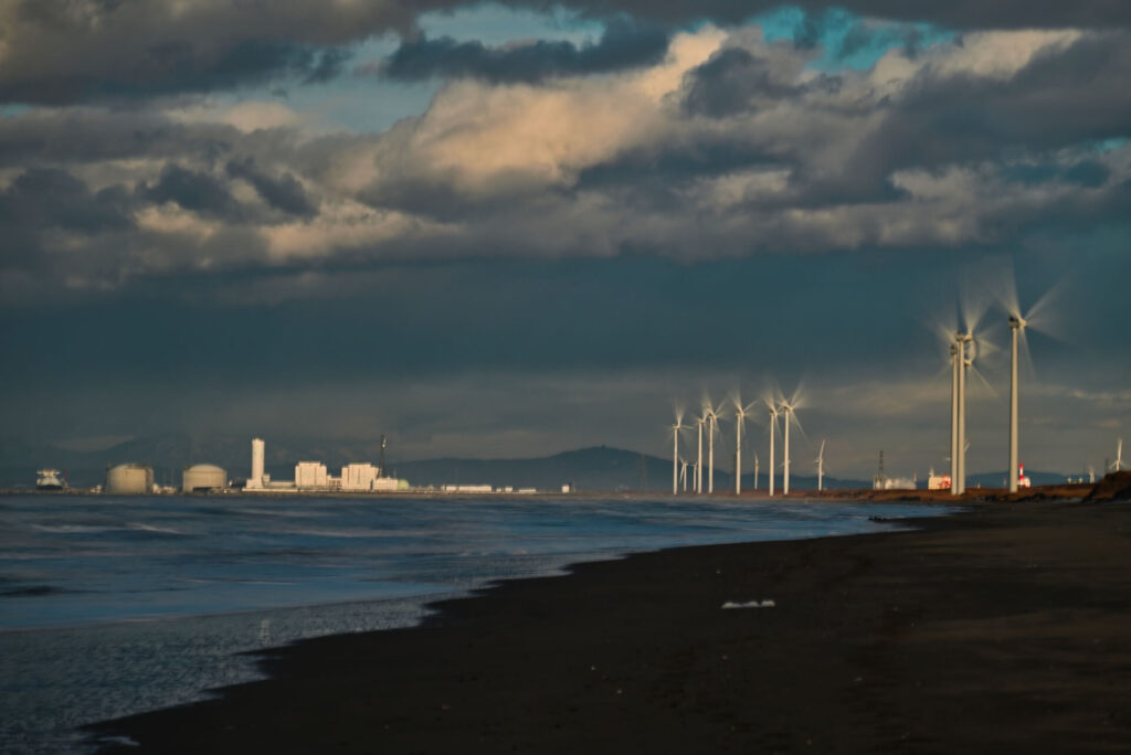 冬の曇り空の下のリエネ銭函風力発電所の風車群（写真左奥には、LNG基地も見える）