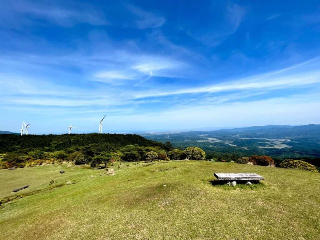 円山草原のベンチと新青山高原風力発電所の風車（円山草原から東側を見た光景、津の街並みが見える）