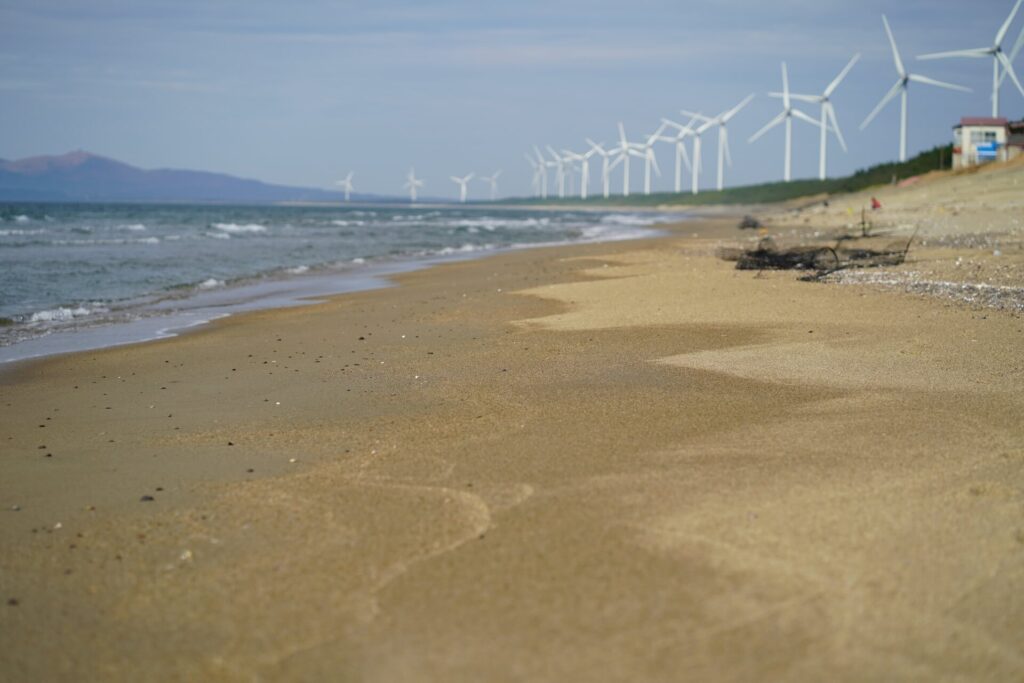 出戸浜海水浴場の浜辺から北に見た、かたがみ風力発電所の風車群