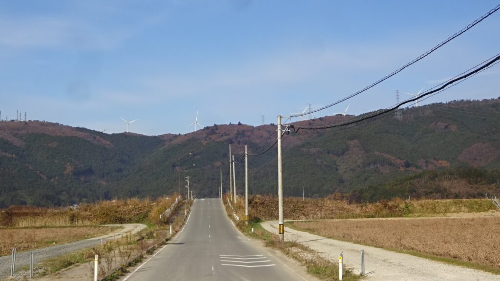 東側の、真野大橋付近から見た石巻ウインドファームの風車
（風車のブレードの黒い二重丸が確認できる）